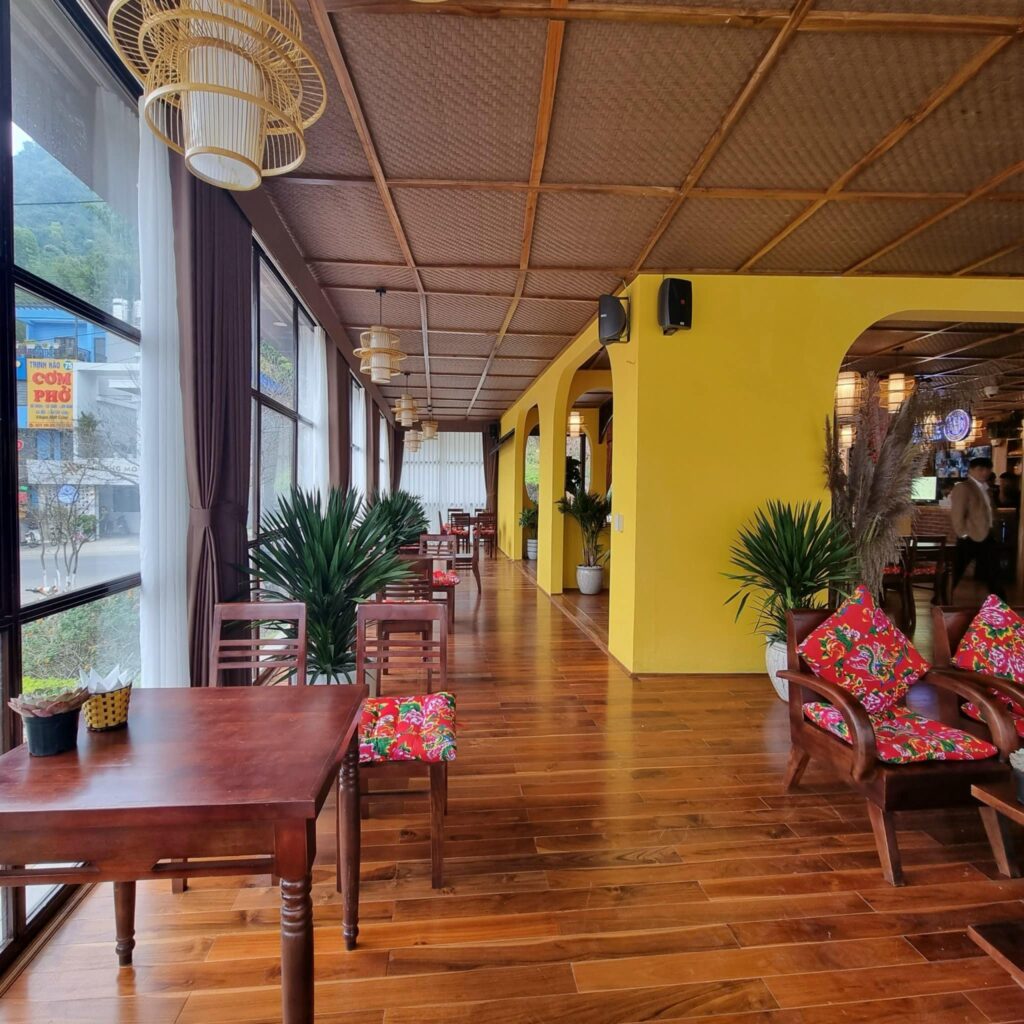 Top 3 Lý Do May Coffee Mộc Châu Chọn Cót Ép Nhân Tạo Cho Trần Nhà 2 Bàn trà đặt gần cửa kính với trần cót ép phía trên tạo chiều sâu cho không gian quán