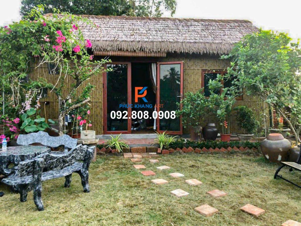 Nhà nhỏ trong sân vườn ốp tường bằng tre nhựa và mái rơm nhân tạo.